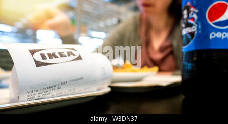 Straßburg, Frankreich - ca. 2019: IKEA Papier eingangs als Frau im IKEA Restaurant Pommes frites und schwedische Fleischbällchen trinken Pepsi süsses Getränk isst Stockfoto