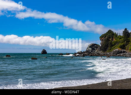 Die Wellen rollen in die Wellen gegen die Felsen in der Ferne im Wilson Creek Strand entlang der Autobahn 101 südöstlich von Crescent City CA und. Stockfoto