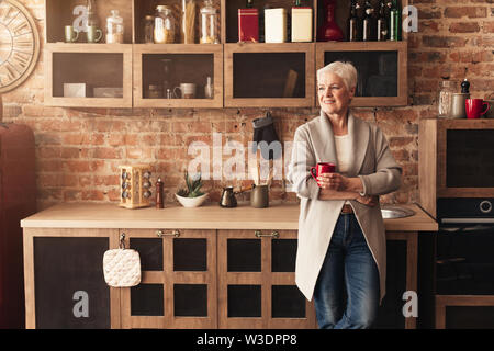 Verträumt senior Frau Kaffee in der Küche Stockfoto