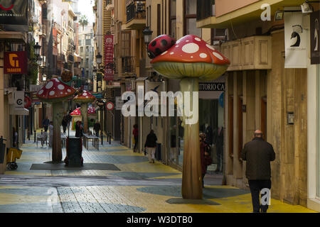 Carrer de Sant Francesc in Alicante, Spanien. Stadt Straße mit ungewöhnlichen Skulpturen der Pilze mit Insekten. Stockfoto