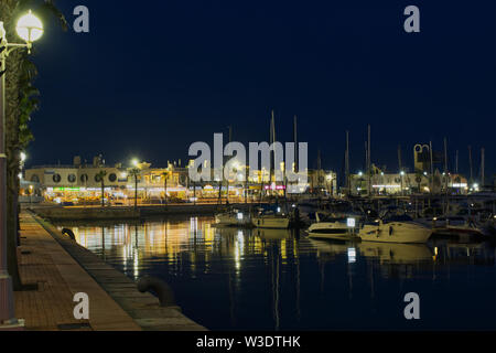 Der Hafen und Yachthafen von Alicante, Spanien. Nacht mit Menschen in Restaurants Stockfoto