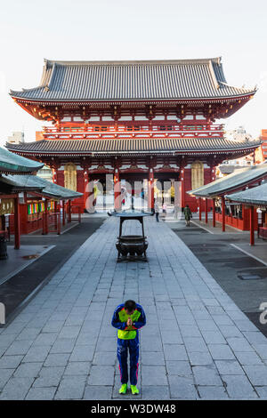 Japan, Honshu, Tokyo, Asakusa, Sensoji-tempel, männlichen Athleten betend im Tempel Stockfoto