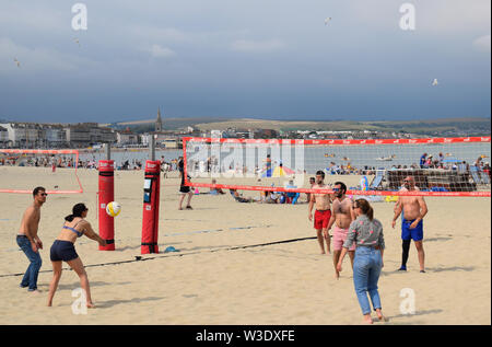 Menschen spielen Beachvolleyball im Sommer am Strand von Weymouth in Großbritannien Stockfoto