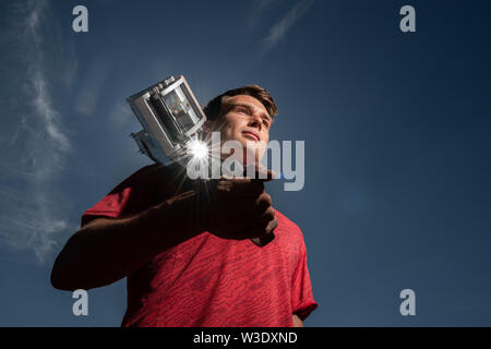 Dresden, Deutschland. 04. Juli, 2019. Sprinter Frieder Scheuschner (Dresdner SC), steht im Heinz-Steyer-Stadion und hat einen Startblock auf seine Schultern. Credit: Robert Michael/dpa-Zentralbild/dpa/Alamy leben Nachrichten Stockfoto