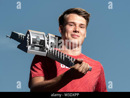 Dresden, Deutschland. 04. Juli, 2019. Sprinter Frieder Scheuschner (Dresdner SC), steht im Heinz-Steyer-Stadion und hat einen Startblock auf seine Schultern. Credit: Robert Michael/dpa-Zentralbild/dpa/Alamy leben Nachrichten Stockfoto