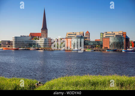 Rostock, Deutschland. Stadtbild Rostocker Flussufer mit Peterskirche im sonnigen Sommertag. Stockfoto