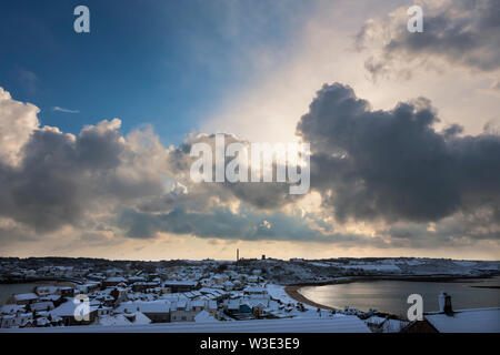 Gewitterwolken und ein Abstauben des Schnees über Hugh Town, St. Mary's, Isles of Scilly, Großbritannien Stockfoto