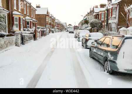 Ramsgate, England. Schlechtes Wetter. Kleinen Seitenstraße mit typisch englischen Terrasse Gehäuse nach Schneefall mit Straße in Schnee und Eis bedeckt. Stockfoto