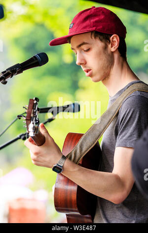 Jake Argyle, junge männliche Sänger der Ramsgate band, Argyle, auf der akustischen Gitarre vor Mikrofon im Freien an lokale Veranstaltung. Stockfoto