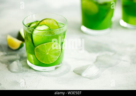 Hausgemachte trendy Eistee Matcha grüner Tee oder Limonade mit Gurke und Limone in einem Glas auf hellgrauem Hintergrund mit Platz für Text kopieren Stockfoto