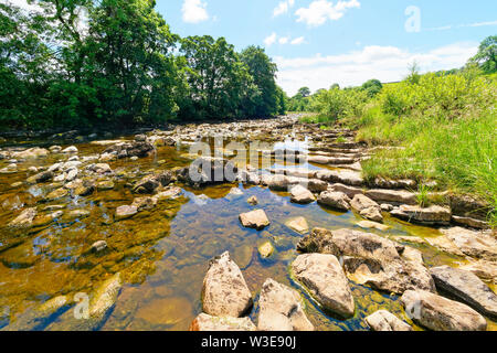 Der Fluss Ribble fließt über und um Felsen und Geröll in der Nähe des Dorfes Stainforth in den Yorkshire Dales Stockfoto