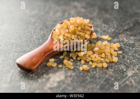 Kristallisiertes brauner Zucker in Löffel aus Holz. Stockfoto