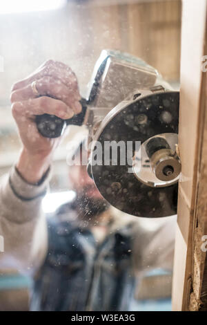 Tischler mit elektrischen Holzbearbeitung Routing ein Holzbrett Stockfoto