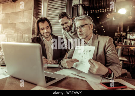 Aufmerksame grauhaariger Mann an seinem Laptop starrend Stockfoto