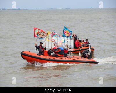 Sheerness, Kent, Großbritannien. Am 15. Juli 2019. T100 Walking Festival von Arts Group Kinetika organisiert ist, mit einer Reihe von 15 Tagen Wanderungen auf beiden Seiten der Mündung der Themse. Heute, Organisatoren und Teilnehmer kreuzte die Mündung der Themse mit Hilfe der Themsemündung Yacht Club (Essex) in zwei ihrer Boote & Landung auf der Insel Sheppey's Sailing Club Helling in Sheerness, Kent, mit anderen Wanderern, die sich in der heutigen Spaziergang von Sheerness zu Münster am Meer zu treffen. Credit: James Bell/Alamy leben Nachrichten Stockfoto