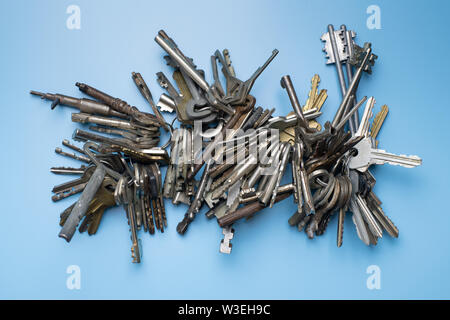 Schlüsselbund für Schlosser. Satz Schlüssel auf blauem Hintergrund. Sammlung von antiken und modernen Tasten. Stockfoto