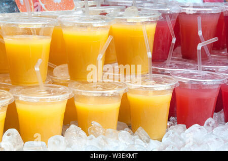 Auswahl von Kunststoff Gläser frischen Orange & Wassermelone Saft für Verkauf an den Londoner Markt Stockfoto