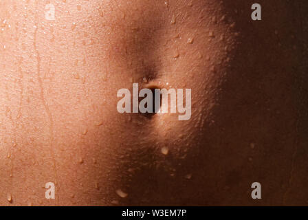 Schönen athletischen gebräunte Körper eines Mädchens aus dem Ozean kommen. Auf dem Bauch sind noch einige Wassertropfen aus dem Ozean. Geeignet für Fitness, Wellne Stockfoto