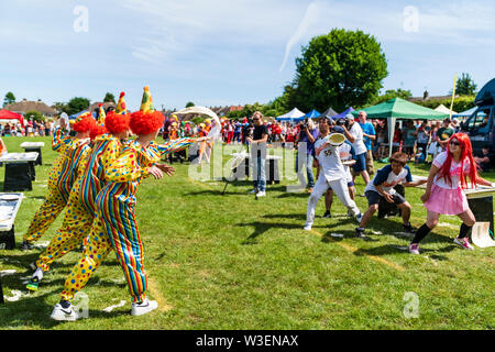 Zwei Mannschaften in Fancy Dress im Außendienst bei der Zuschauer, werfen Custard pies an einander bei der jährlichen Welt Custard Pie Meisterschaft 2019. Stockfoto