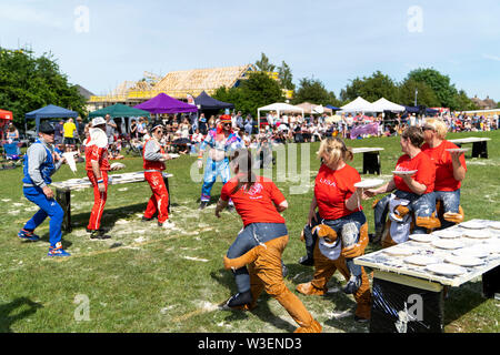 Zwei Mannschaften in Fancy Dress im Außendienst bei der Zuschauer, werfen Custard pies an einander bei der jährlichen Welt Custard Pie Meisterschaft 2019. Stockfoto