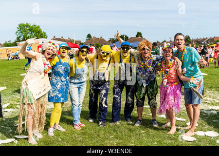 Welt custard Pie-Meisterschaft. Zwei Vanillepudding abgedeckt Teams im Halbkreis steht für den Betrachter mit Arme um ihre Schultern. Stockfoto