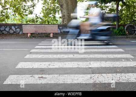 Schwarze und weiße Fußgängerüberweg mit einem Motorroller auf Hintergrund Stockfoto