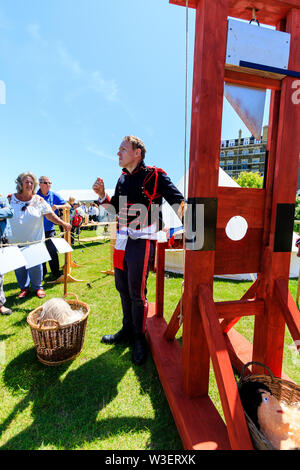 Broadstairs Dickens Festival. Mann verkleidet als die französischen Revolutionäre Soldaten aus "Geschichte zweier Städte" für Personen wie die Guillotine funktioniert, erklärt. Stockfoto