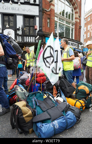 London, Großbritannien. 15. Juli 2019. Der Demonstrant Rucksäcke in einem Stapel als Aussterben Rebellion bringen den Verkehr zum Erliegen außerhalb der Royal Courts of Justice. Quelle: Thomas Bowles/Alamy leben Nachrichten Stockfoto