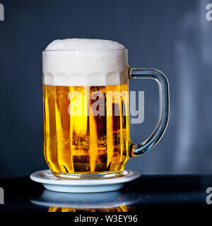 Glas Bier mit Tropfen von Wasser Stockfoto