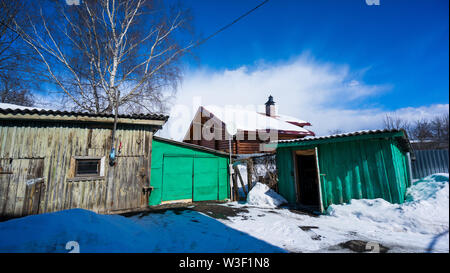 Alte hölzerne Dorf Haus mit Nebengebäuden im Winter. Reisen nach Russland Stockfoto