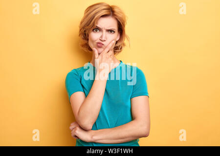 Stirnrunzelnd unglücklich frustrierten Frau mit einem Palm auf ihrem Kinn drückt sich negative Emotionen, Nahaufnahme, Porträt, Frustration Konzept Stockfoto