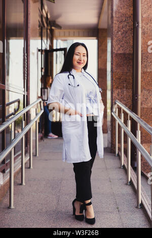 Closeup Portrait von freundlichen weiblichen asiatischen medical student. Menschen - ein Arzt, eine Krankenschwester und ein Chirurg auf dem Hintergrund der Hochschulen Stockfoto