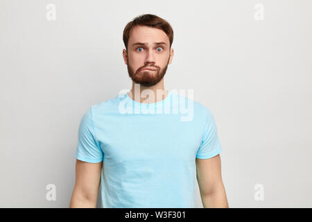 Junge lustig Mann in stilvoll-T-Shirt auf blauem Hintergrund isoliert, Studio erschossen. Gesichtsausdruck. Emotion und Gefühl Stockfoto
