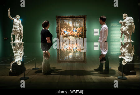 Galerie Arbeiter sind in einer Vitrine wider, wie sie anzeigen Nicolas Poussin Der Triumph der Pan, eines der bedeutendsten Werke der National Gallery, und das Kernstück der National Gallery Meisterwerk Tour 2019, derzeit an der York Art Gallery in Yorkshire. Stockfoto