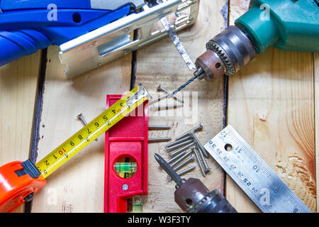 Elektrische Bohrmaschine, Mutter, Maßband, elektrische Säge, Lineal, Schraubendreher, Werkzeuge für die Holzbearbeitung Konzept Baumaschinen Stockfoto