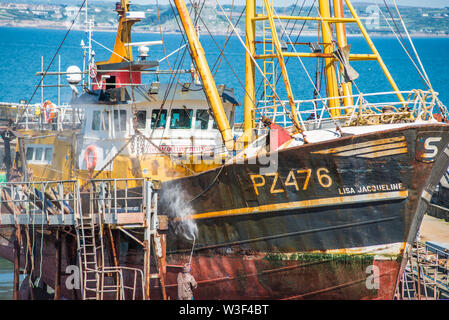 Alte Fischtrawler mit gedrueckt Wasserstrahl auf Newlyn Fischerdorf in der Nähe von Penzance in Cornwall, England, Großbritannien. Stockfoto