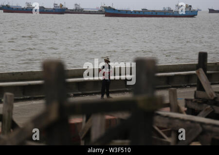 Chittagong, Bangladesch. 14. Juli, 2019. Ein Fotograf, der für Clients, die an Patenga Meer Strand in Chittagong, Bangladesch. Patenga ist ein Meer Strand liegt 14 Kilometer südlich der Hafenstadt Chittagong, Bangladesch. Es liegt an der Mündung des Karnaphuli River. Patenga ist ein beliebter Ort für Touristen. Bild: Sultan Mahmud Mukut/SOPA Images/ZUMA Draht/Alamy leben Nachrichten Stockfoto