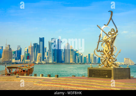 Doha, Katar - Februar 23, 2019: Kalligraphie Skulptur auf der Strandpromenade Corniche, hölzernen Dhow und Doha West Bay Skyline mit Doha Tower, Salam Stockfoto