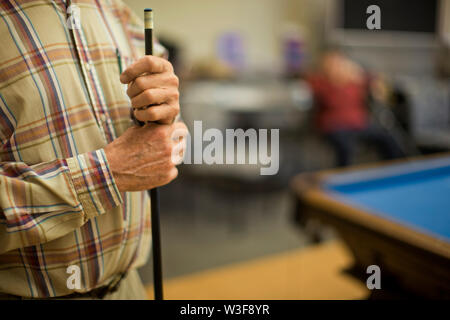 Hände von ein älterer Mann mit einer Pool cue. Stockfoto