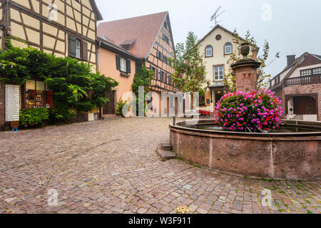 Eines der vielen mit Blumen geschmückter Brunnen im Dorf Riquewihr, Elsass, Frankreich, Platz des Dorfes Stockfoto