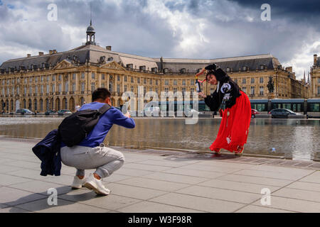 Japanische Touristen fotografieren, Place de la Bourse. Die neuen Brunnen Miroir d'Eau, Wasser spiegeln. Bordeaux, Gironde. Region Aquitanien. Frankreich Europa Stockfoto