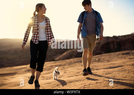 Glückliches junges Paar, das Spaß, während sie wandern gemeinsam mit ihrem Hund. Stockfoto