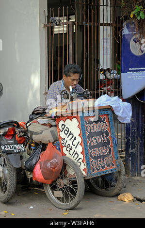 Jakarta, dki Jakarta/Indonesien - Mai 18, 2010: Ein individuelles Arbeiten bei seinem mobilen Nähmaschine auf Jalan kemenangan 3 in glodok Stockfoto