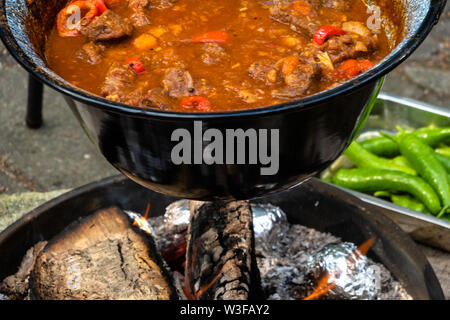 Bereit Kesselgulasch nach vier Stunden Kochen über offenem Feuer. Mit Tomaten, Rindfleisch, Zwiebeln, Knoblauch, Sellerie und Karotten. Stockfoto