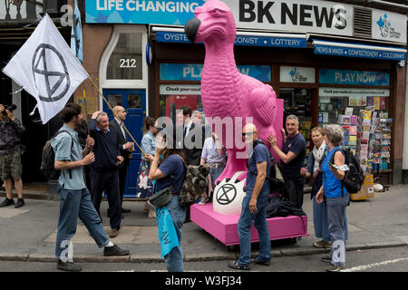 Ein rosa Dodo ist durch Londons Straßen schob En-route, wo andere Umwelt- und Klimawandel Demonstranten Fleet Street am ersten Tag einer Woche Block - lange landesweite Proteste mit Hilfe von fünf Boote Verkehr in Cardiff, Glasgow, Leeds, Bristol und London zu stoppen, die am 15. Juli 2019 in London, England. Die Gruppe fordert von der Regierung ein Klima Notstand auszurufen, sagen war Anfang fünf - "Summer's day Aufstand" und "Umweltzerstörung" sollte eine Straftat im Recht zu sein. Stockfoto