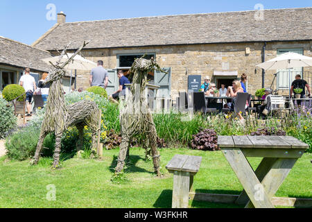 Besucher genießen den Sommer Sonnenschein außerhalb der Morris und Braun Cafe am Broadway Tower in den Cotswolds Stockfoto