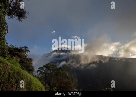 Swing am Ende der Welt gegen Vulkan Tungurahua im Sonnenuntergang Explosion Stockfoto