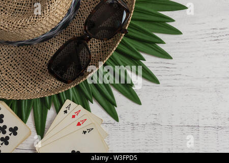 Konzeptionelle Bild für Ferienhäuser, Karten spielen, oder gewinnende Hand, mit Stroh Hut und Sonnenbrille für Männer, einen Satz Karten, vier Asse, auf dem Hintergrund der alten Stockfoto