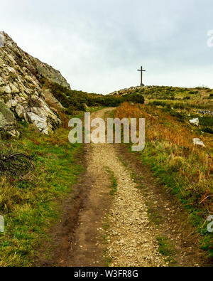 Ein steiniger Weg zum Kreuz hoch oben auf Bray Head in der Grafschaft Wicklow, Irland entfernt Stockfoto