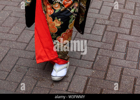 Frau in der traditionellen japanischen Kleidung zu Fuß auf einer Straße, einer Stadt Stockfoto